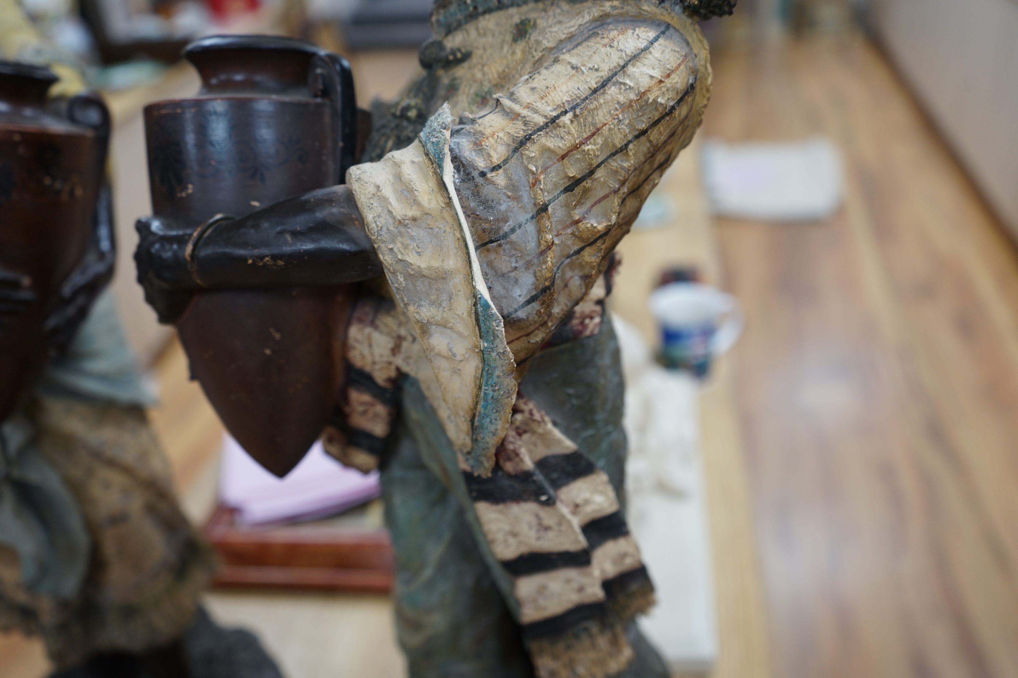 A pair of Continental painted pottery figures of Nubian water carriers, tallest 89cm high